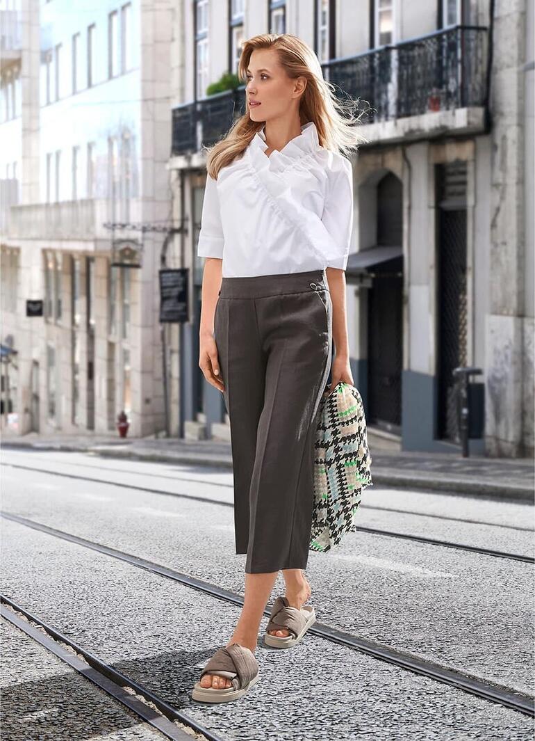 Gris Femme avec un foulard pied-de-poule regardant dans la rue.