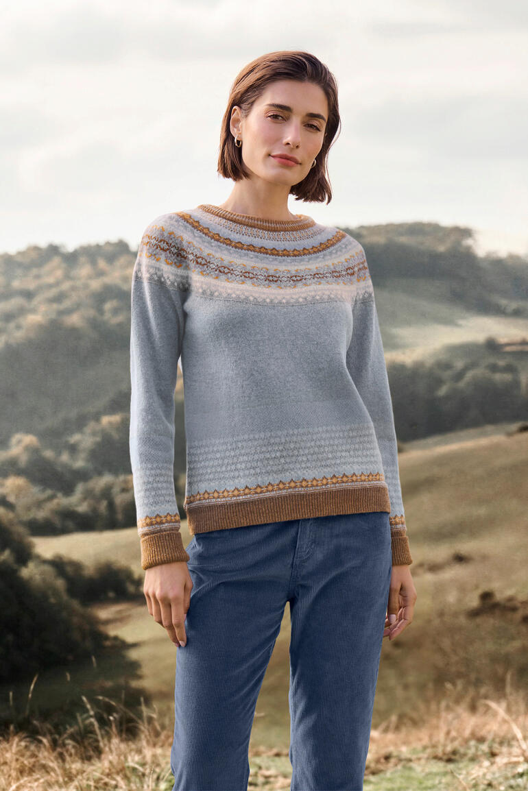 Pull-over Fair-Isle 6 couleurs Femme en pull Fair Isle souriante se tenant dans un champ.