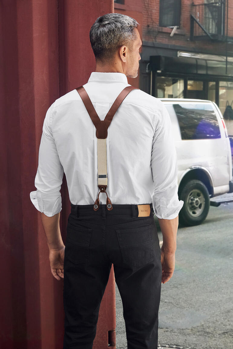 Homme avec des bretelles en cuir et une chemise blanche vu de dos en ville.