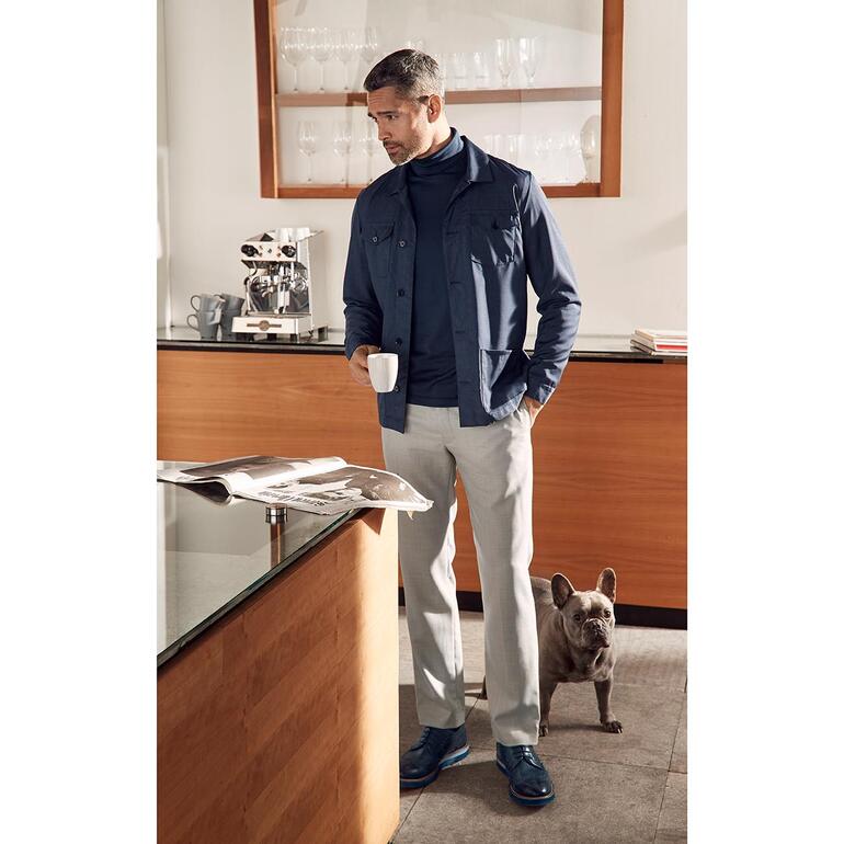Pantalon en toile hopsack Homme en pantalon en laine Hopsack marine, debout dans une cuisine moderne.