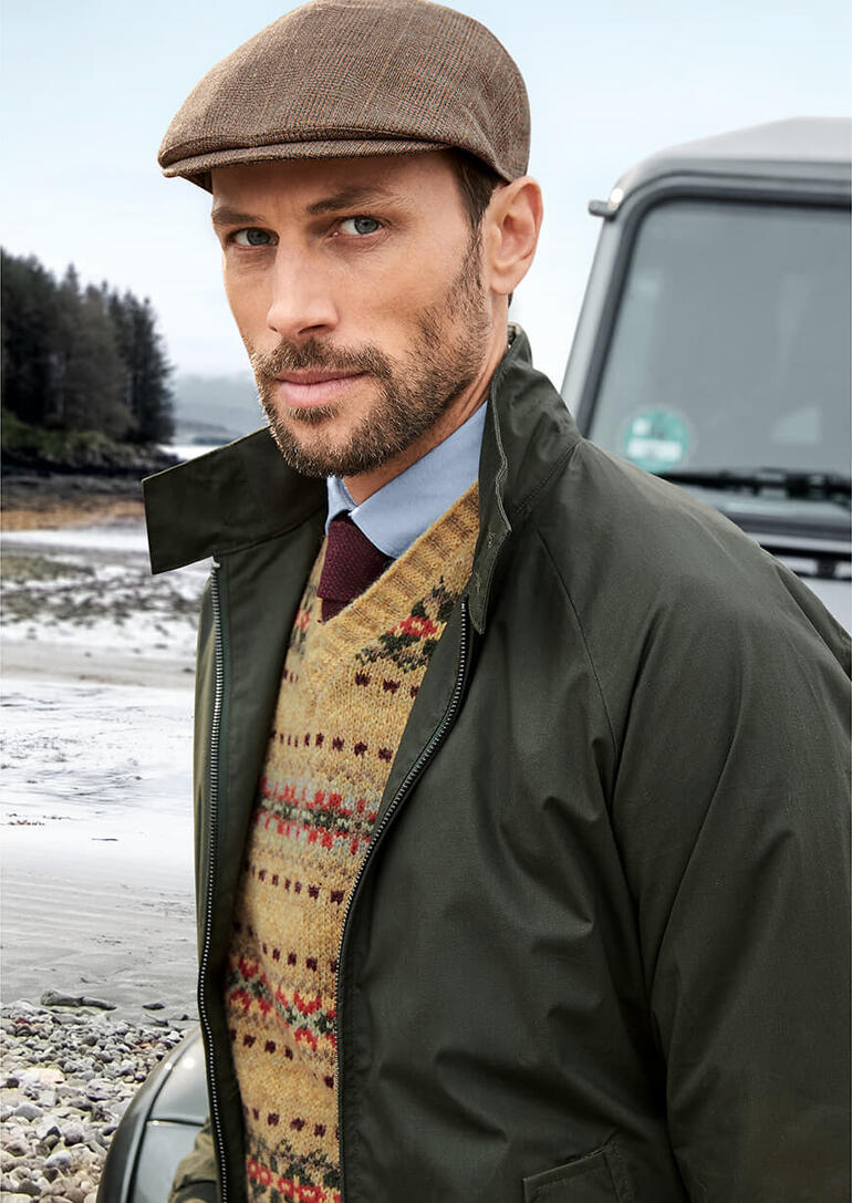 Homme portant un pull V Fair-Isle Edward devant un véhicule.