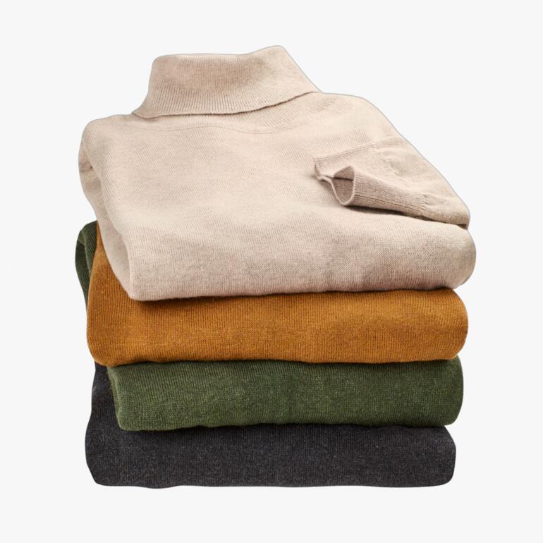 Pile de pulls col roulé en tricot fin de différentes couleurs.