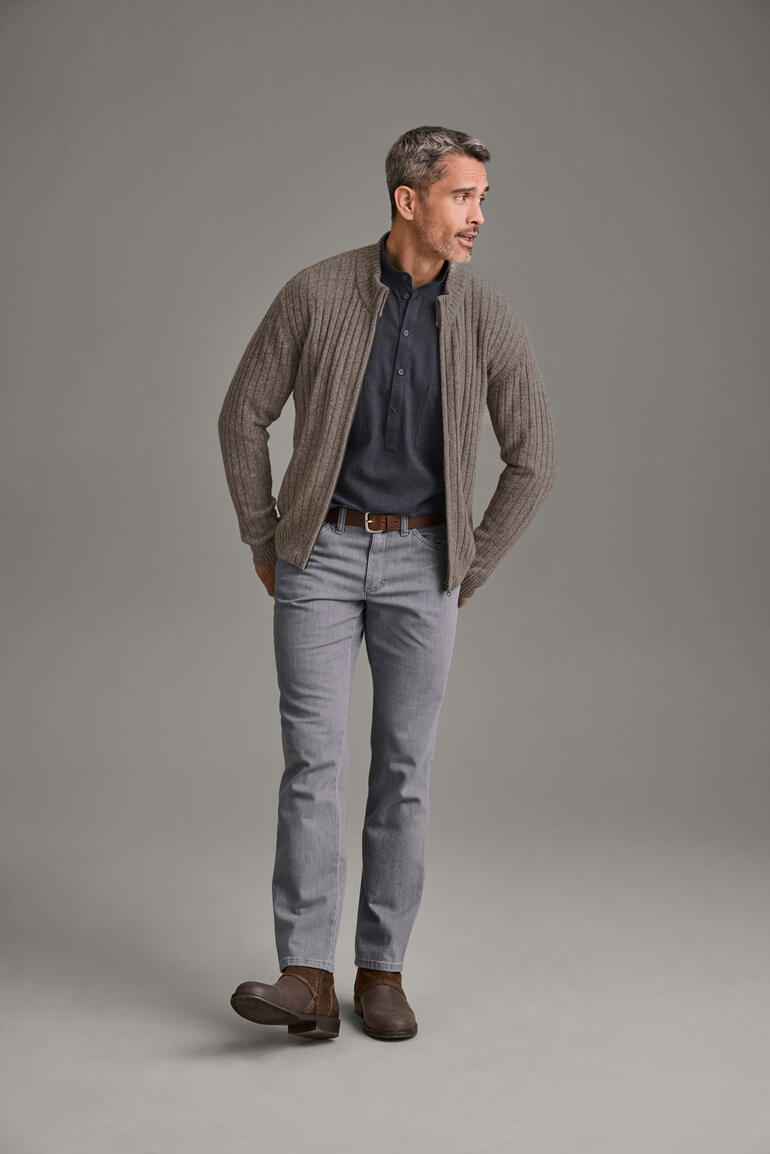 Homme portant un cardigan en yak beige sur une chemise bleue et un pantalon gris