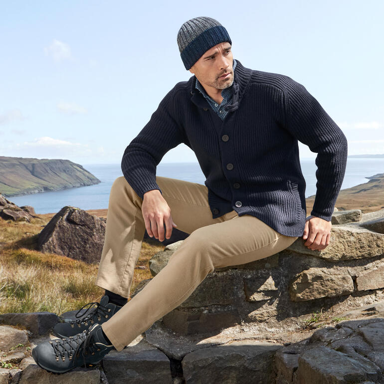 Cardigan Raglan Fisherman bleu foncé porté par un homme en pleine nature.