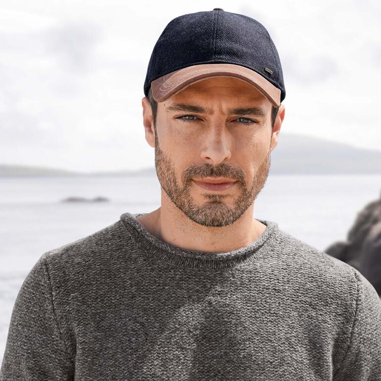 Casquette en cuir et tweed, Bleu marine Homme portant une casquette en cuir Tweed navy sur la plage.