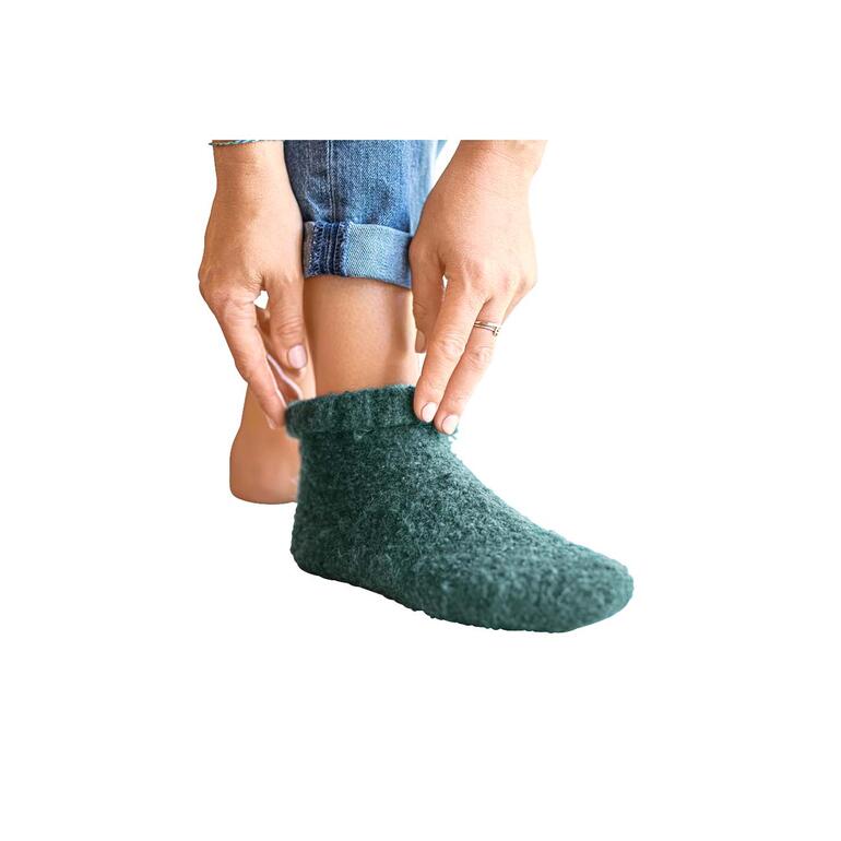 Femme enfilant la botte Gottstein Walkstrick verte.