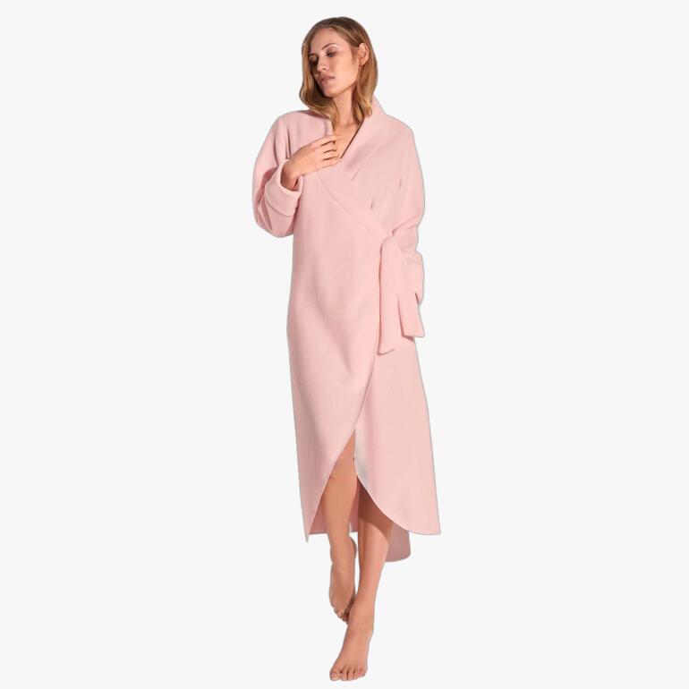 Peignoir en polaire rose pastel enroulé autour d'une femme.