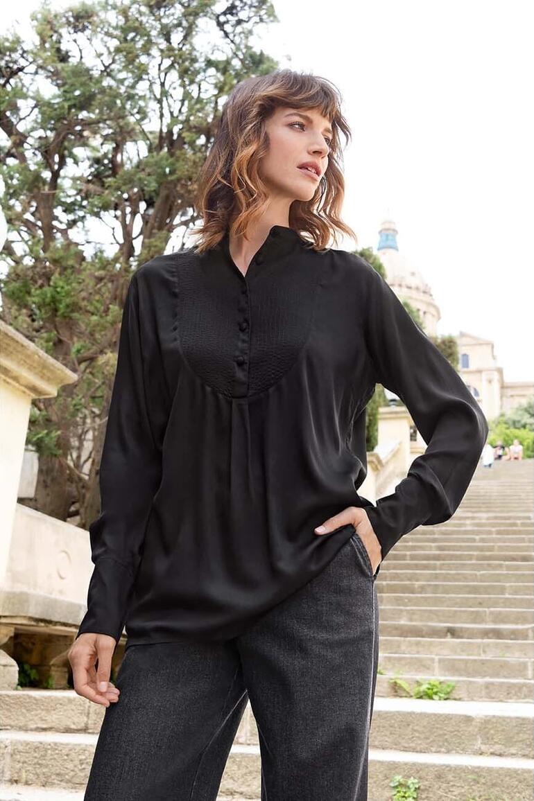 Tunique à plastron Neu Nomads Femme en tunique plastron noire sur un escalier dans un parc.