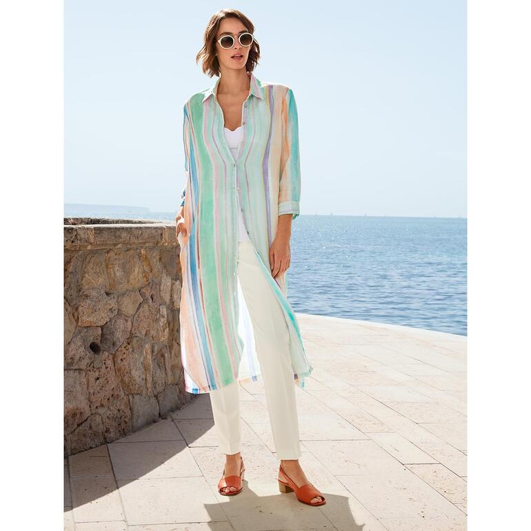Blanc Femme dans un pantalon d'été 24 heures, debout au bord de l'eau.
