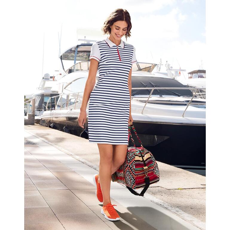 Femme en robe polo rayée de Saint James, se déplaçant au port avec un sac.