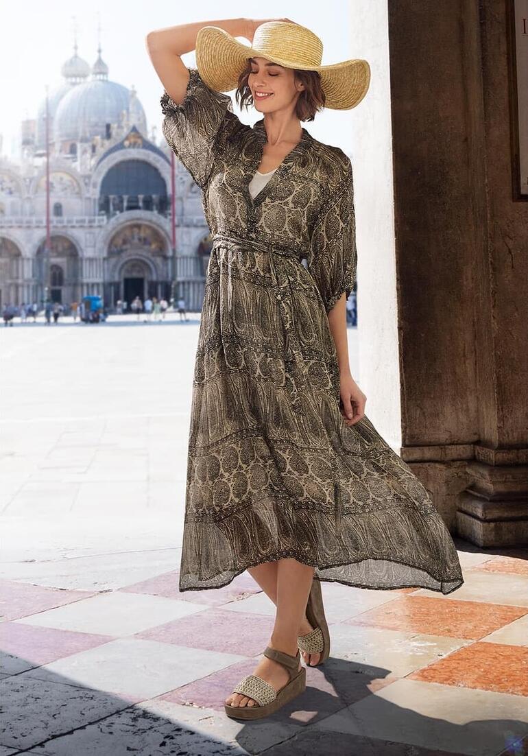 Femme en robe longue à motifs et chapeau de paille à Venise.