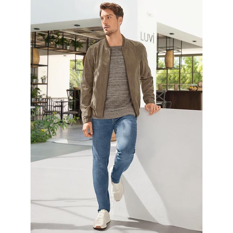 Blouson Amaretta Schneiders Homme en blouson Amaretta, appuyé contre un mur dans un intérieur moderne.