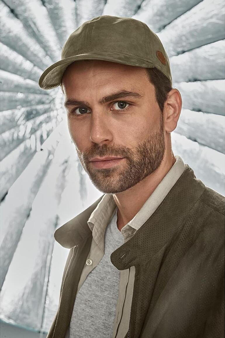 Casquette de baseball en suède MJM Homme en casquette en daim, debout devant un fond réfléchissant.
