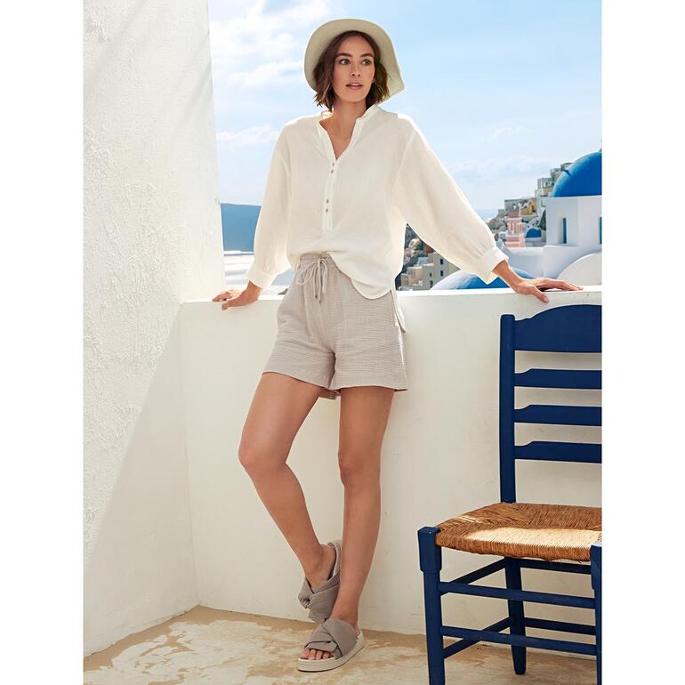 Tunique et Short Femme portant une tunique Tetra blanche et un short sur une terrasse.