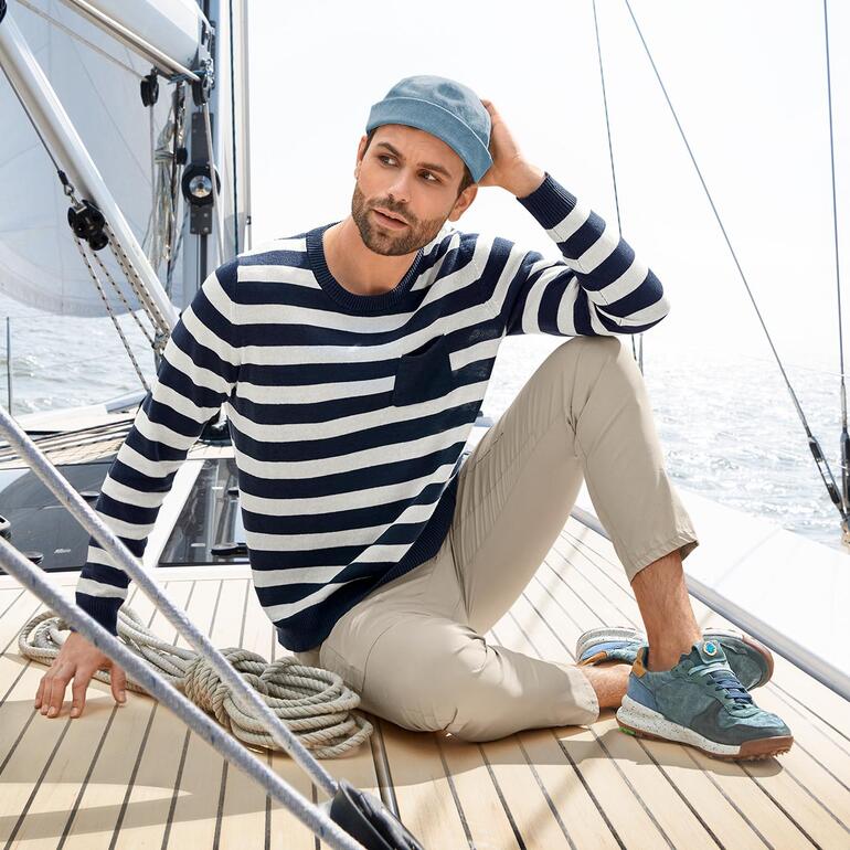 Pull maritime estival Homme en pull rayé et pantalon cargo Zero-Gravity sur un voilier.