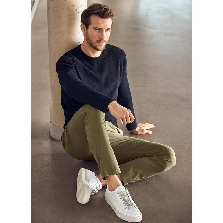 Chino 116 g Homme assis en chino 116 gram olive avec un pull noir.