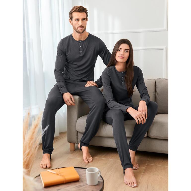 Couple en pyjamas anti-insectes grises sur un canapé.