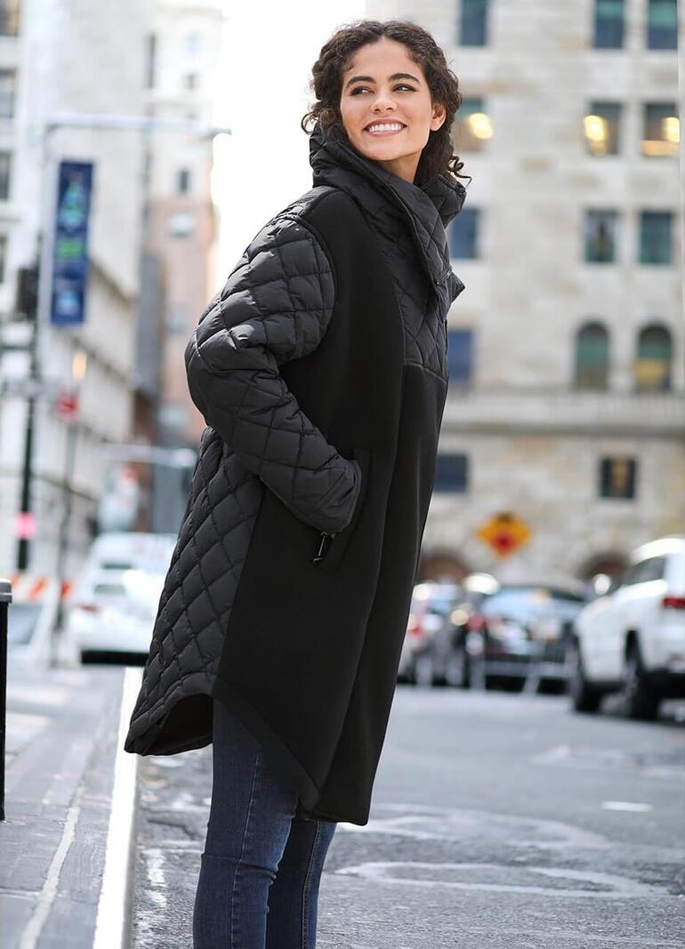 Manteau couture Goldbergh Manteau femme noir avec manches matelassées, vue de rue.
