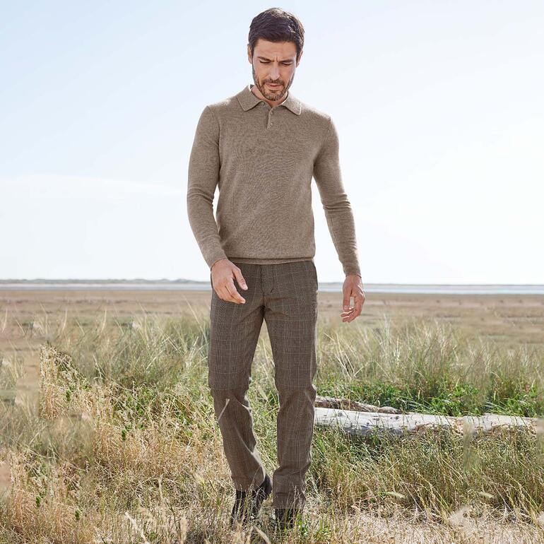 Homme dans un pantalon confortable à motif écossais et un pull, dehors dans la nature.