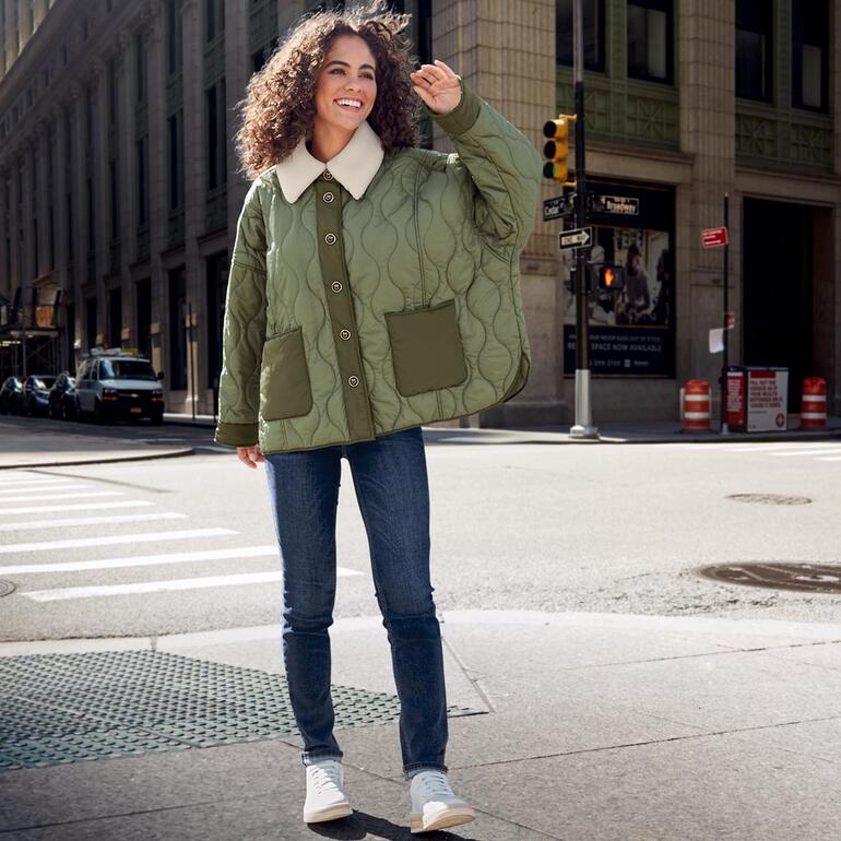 Sneaker vintage WOMSH Femme portant des baskets vintage avec une veste claire dans la rue.