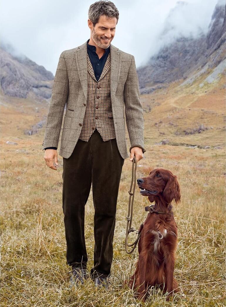 Veste Carl Gross Harris Tweed, modèle avec un chien dans un cadre naturel.