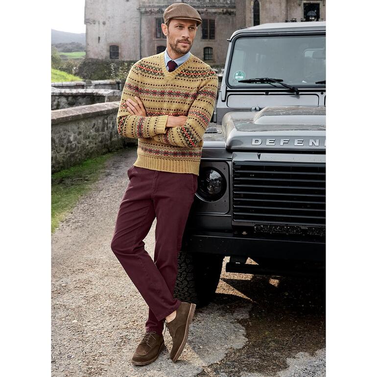 Pull Edward à col en V Fair-Isle Homme en pull-over Fair-Isle V Edward se tenant à côté d'un 4x4.