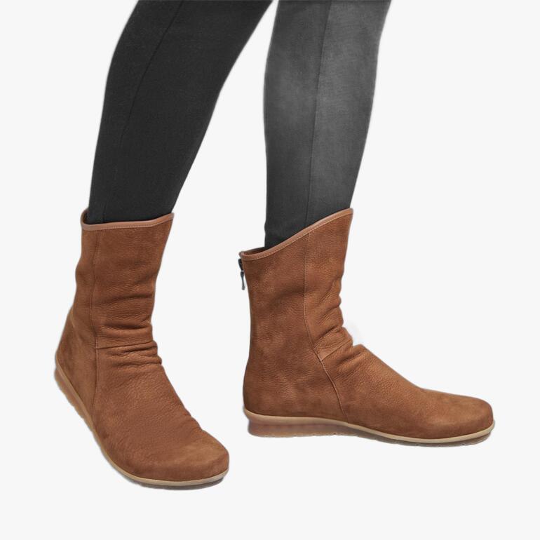 Bottine en cuir de taureau arche marron, portée décontractée par une personne en leggings noirs.