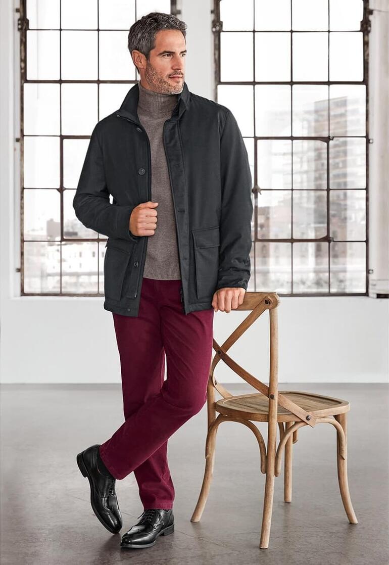 Manteau Storm-System® Schneiders Homme dans une veste Schneiders Storm-System® devant une fenêtre dans un environnement moderne.