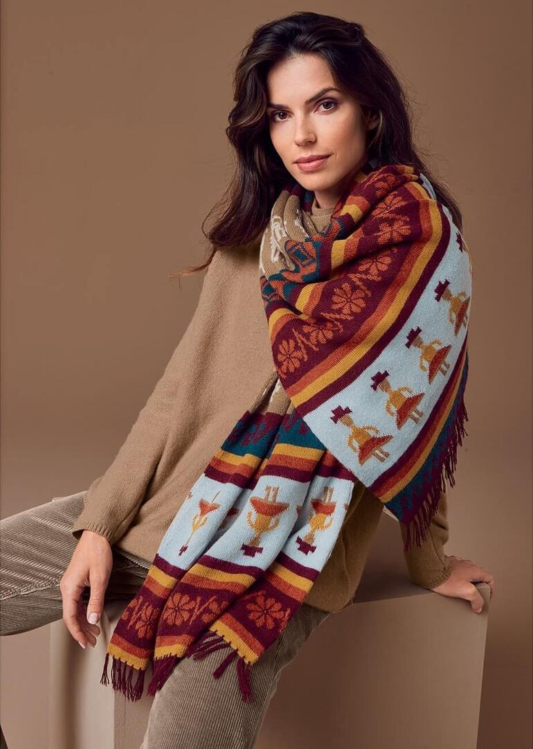 Femme avec écharpe en alpaga tricotée à la main regardant la caméra.