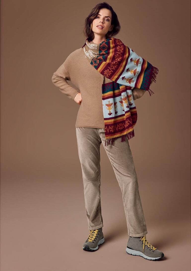 Taupe Femme portant une écharpe en alpaga tricotée à la main avec un pull beige et un jogging.
