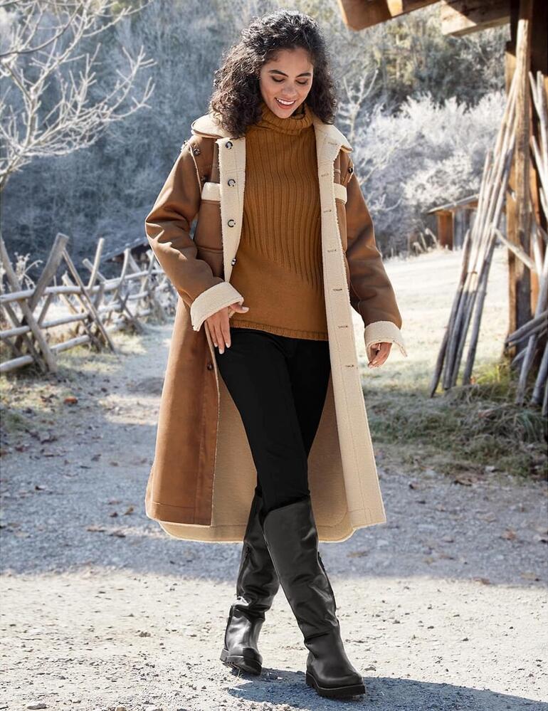 Noir Femme portant un pantalon long et élégant, associé à un long manteau.