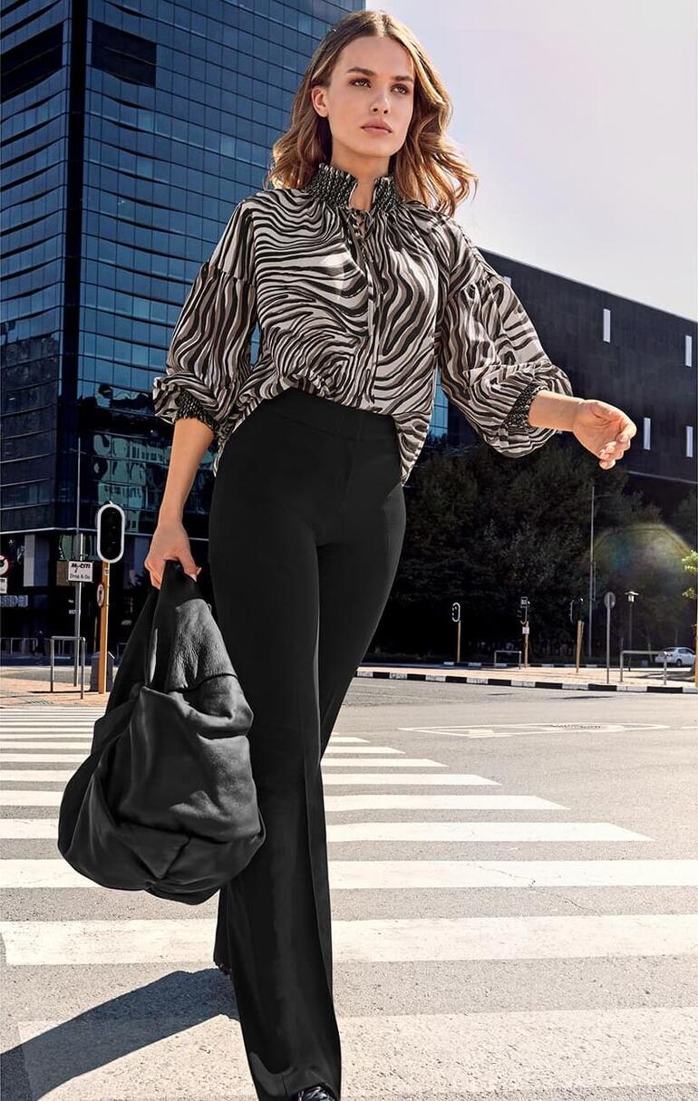 Blouse tunique en laine/soie Joyce & Girls Femme en blouse rayée marchant dans une rue d'un environnement urbain.