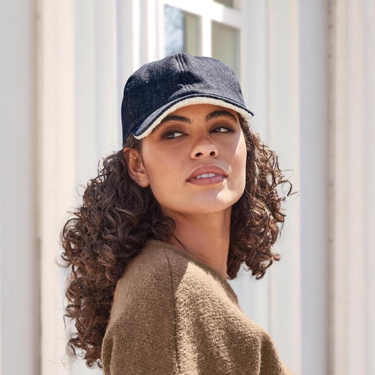 Casquette en denim et polaire Roeckl Casquette en denim teddy bleu foncé, portée par une femme.