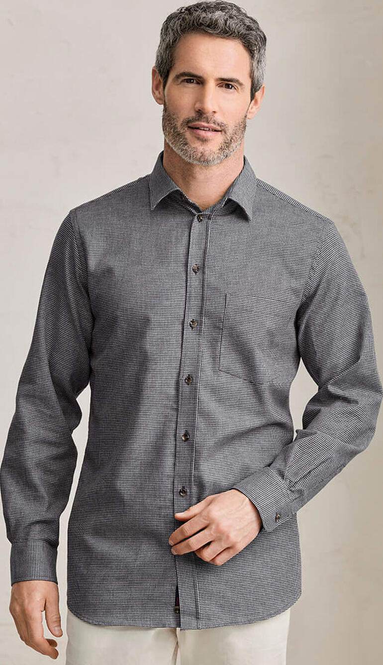Homme portant une chemise en flanelle de cachemire grise avec motif vichy et poche poitrine.