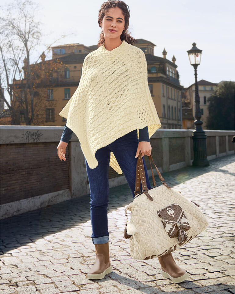 Marron Femme en poncho beige en crochet avec un jean à l'extérieur.