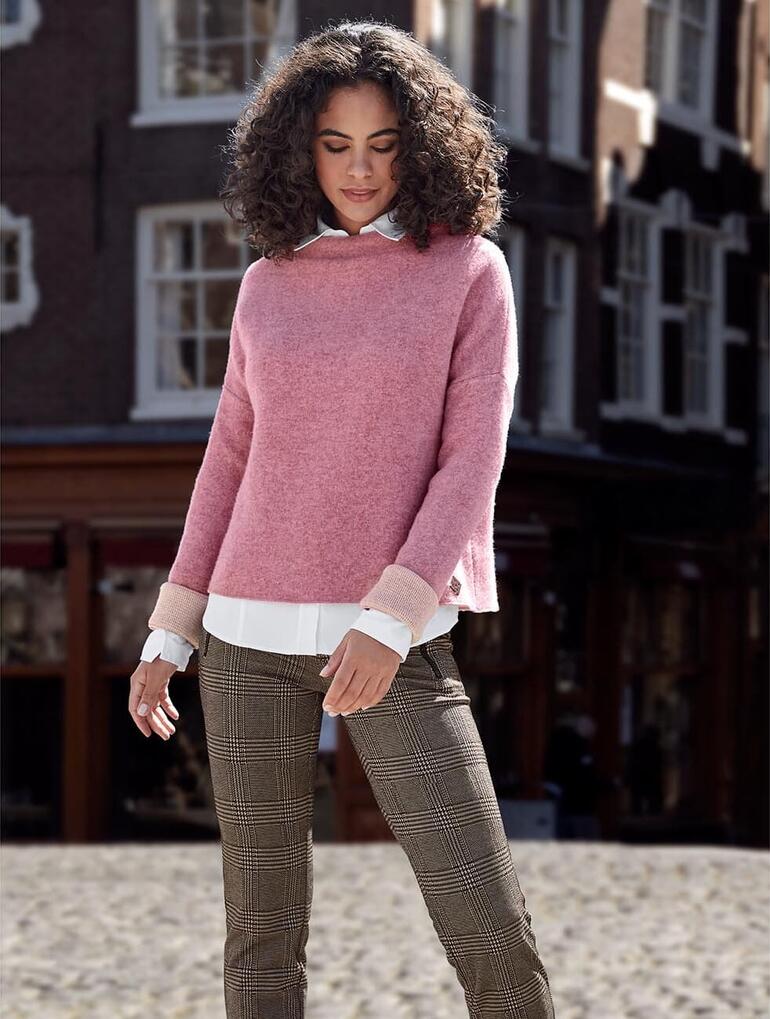 Femme avec pull en laine sur une rue pavée