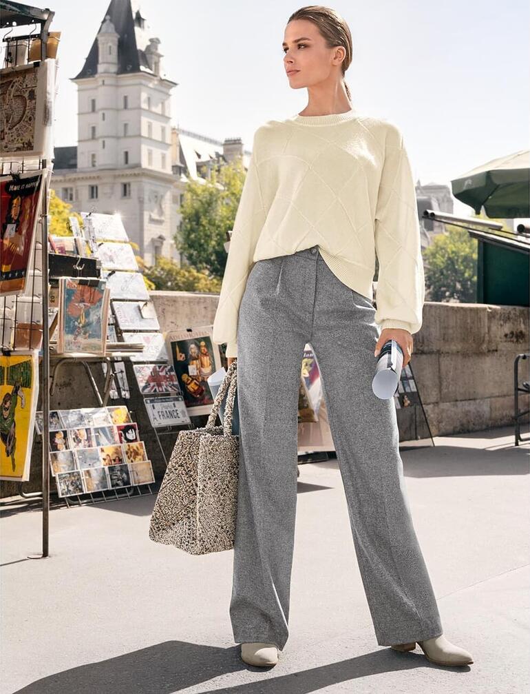 Gris Femme portant un pull en panier Junghans avec un pantalon gris et un sac en tissu.