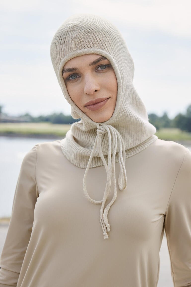 Femme portant une balaclava tricotée en ecru avec cordon