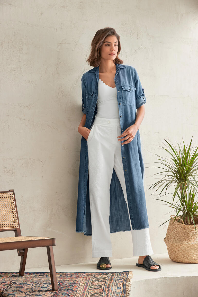 Robe-chemisier en jean Bella Dahl Femme en robe en jean se tient devant un mur avec une plante.
