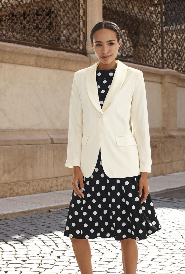 Blazer en soie blanche sur une robe à pois, look élégant.