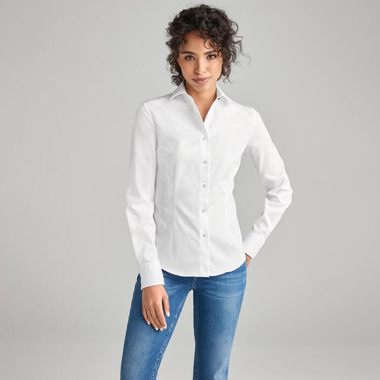 Femme portant une blouse QuickClean blanche avec col montant et boutons.