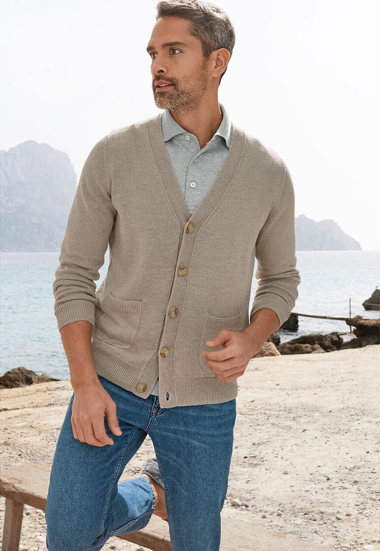 Homme en cardigan en lin marchant le long de la plage