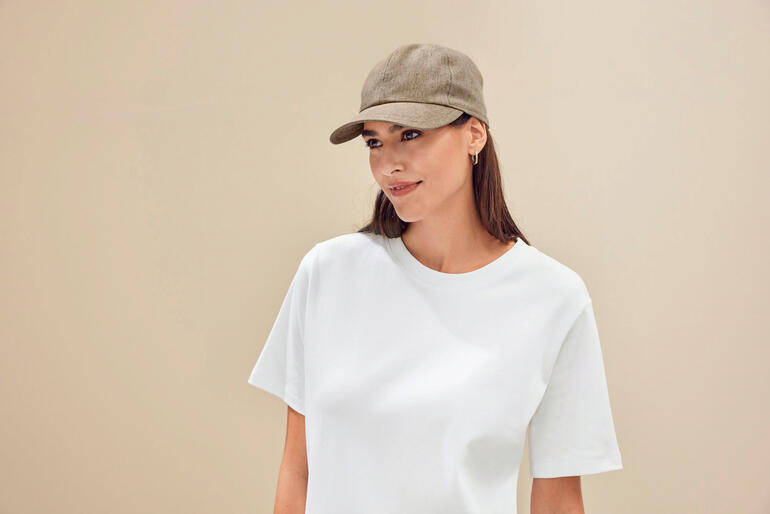 Sable Femme en T-shirt clair portant une casquette et souriante.