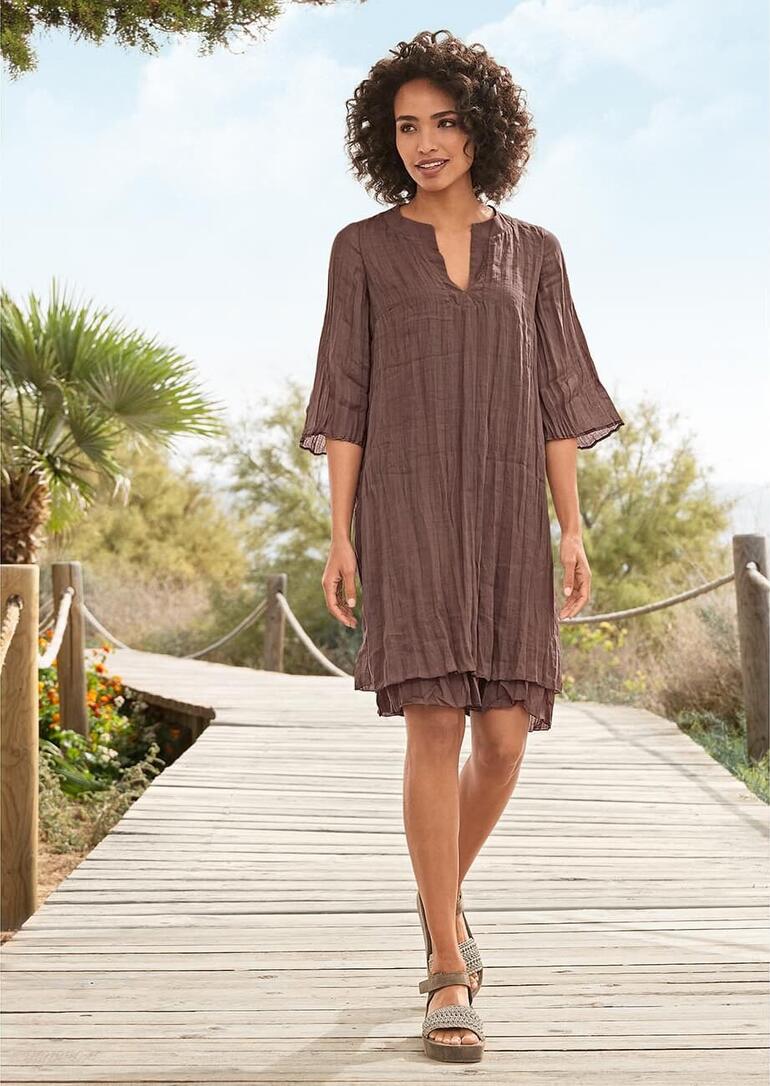 Robe look superposé European Culture Femme portant une robe en chocolat à superposer sur un chemin en bois.