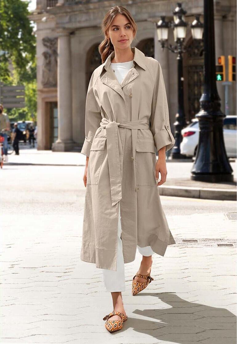 Femme en trench-coat d'été en lin/coton dans la rue