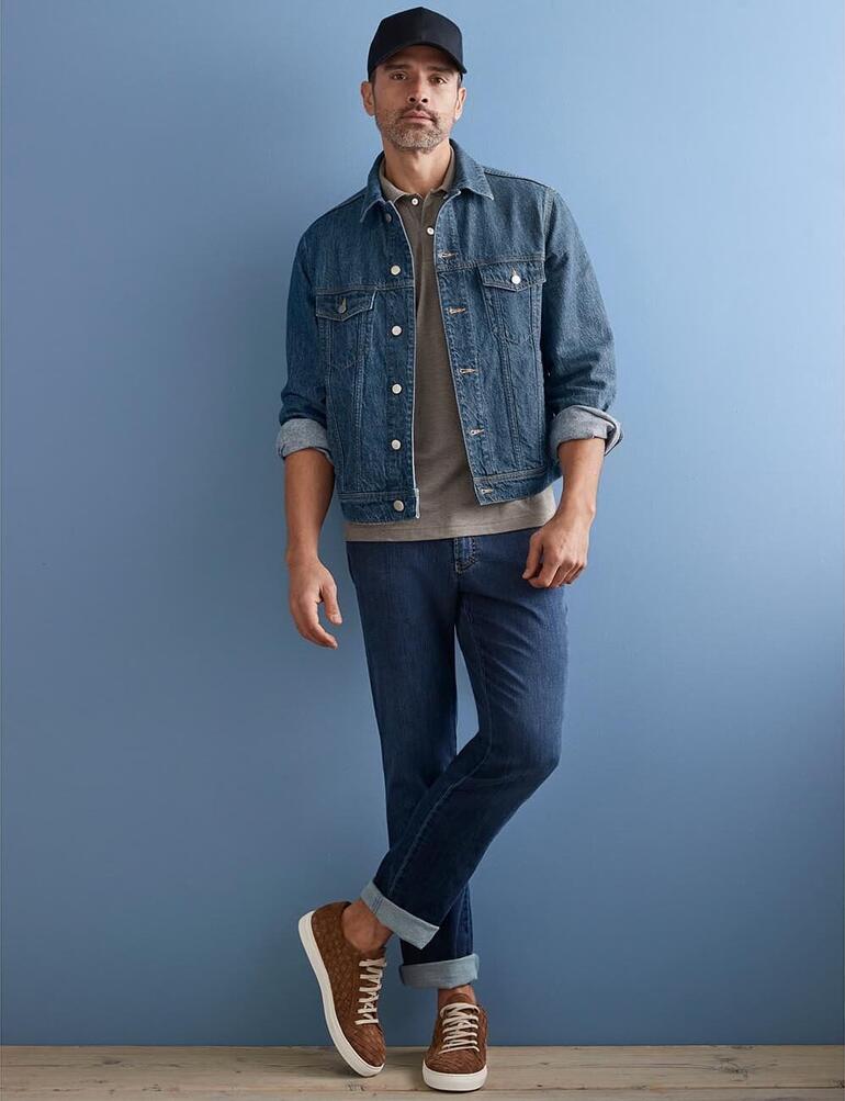 Veste en jean et chanvre OCONI Homme en veste en jean de chanvre, debout de manière décontractée devant un mur bleu.