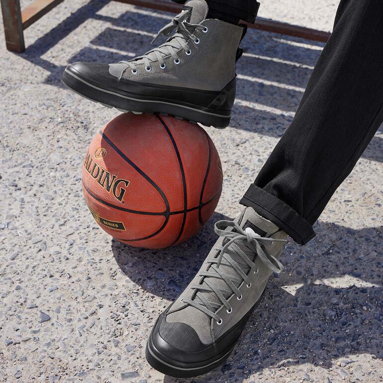 Sneaker de basketball imperméable Sorel noire sur un ballon de basketball.