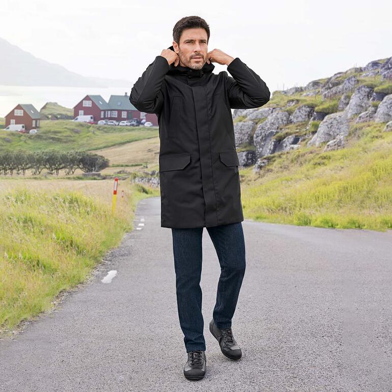 Jean en laine Eurex by Brax Homme en manteau noir et jeans en laine sur un chemin.