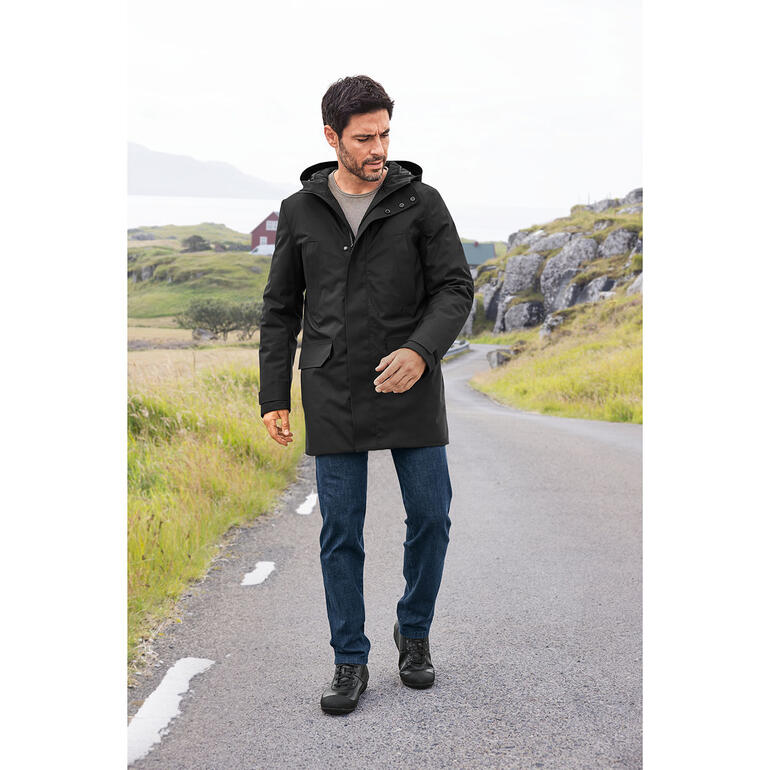 Sneaker Biker Franz Gustav Homme en manteau noir et jeans en laine sur un chemin.