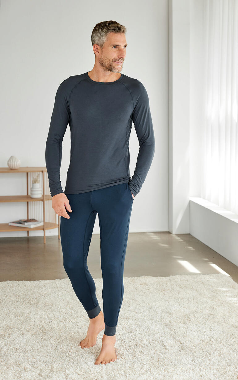 Homme en pyjama Dagsmejan, composé d'un shirt à manches longues et de leggings en gris foncé.